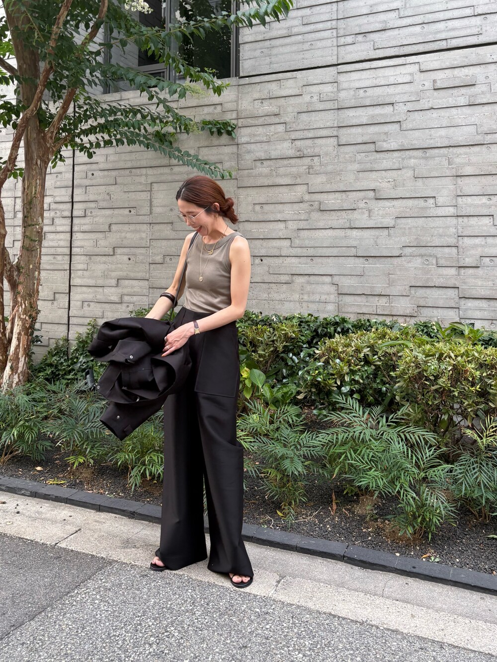 ブラック系のその他パンツ、グリーン系のタンクトップ、ブラック系のその他アウターを着用したレディースの秋コーディネートの3枚目の写真