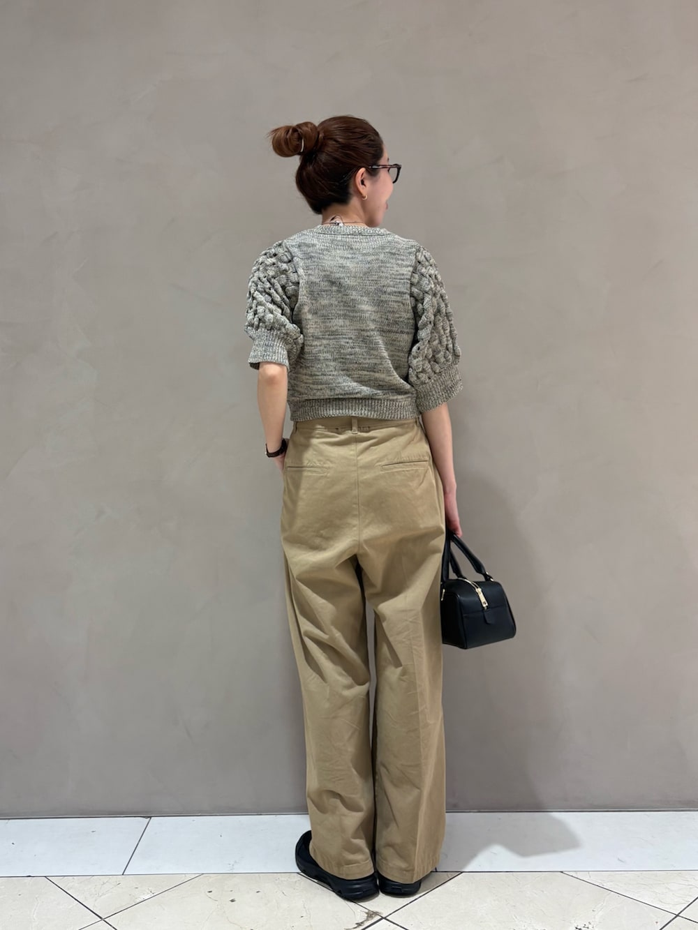 ベージュ系のその他パンツ、ブラック系のハンドバッグ、ホワイト系のニット/セーターを着用したレディースの春コーディネートの4枚目の写真