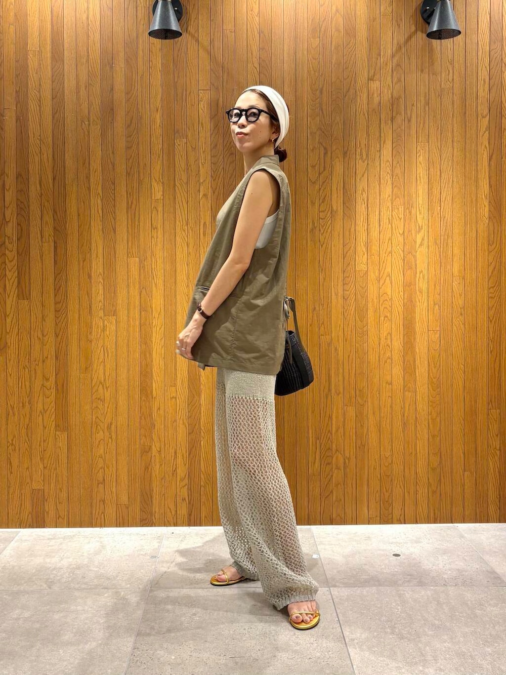 ブラック系のかごバッグ、ゴールド系のサンダル、グレー系のその他パンツを着用したレディースの夏コーディネートの6枚目の写真