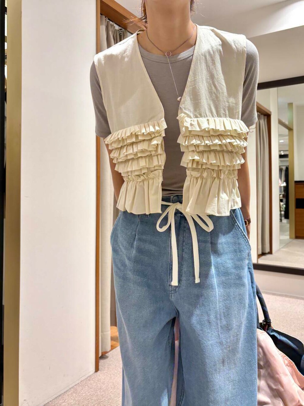 ピンク系のトートバッグ、ブルー系のデニムパンツ、ホワイト系のシャツ/ブラウスを着用したレディースの夏コーディネートの8枚目の写真