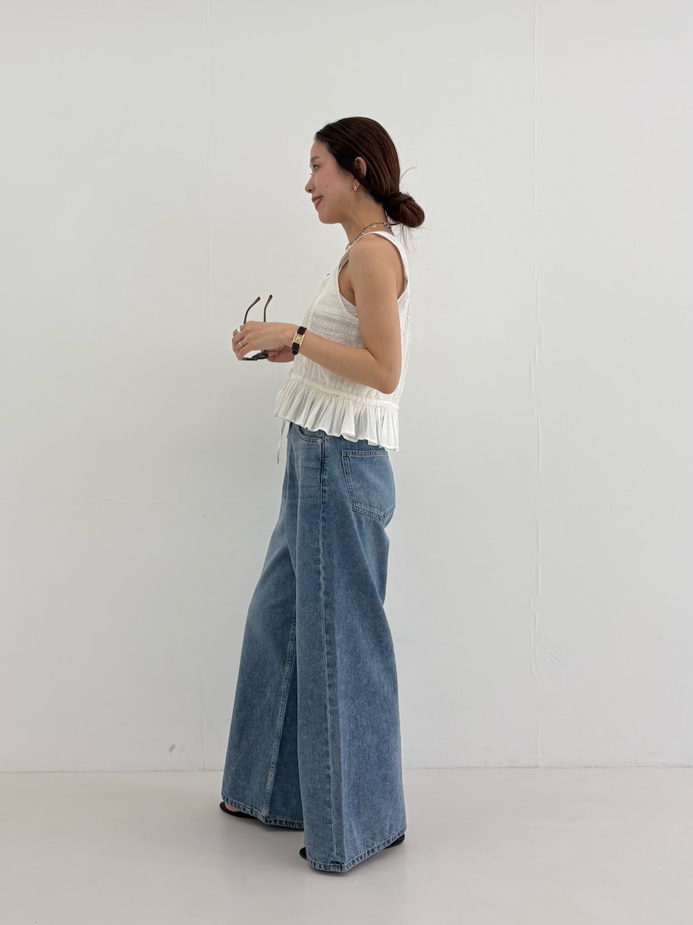 ブルー系のデニムパンツ、その他のトートバッグ、ホワイト系のシャツ/ブラウスを着用したレディースの夏コーディネートの2枚目の写真