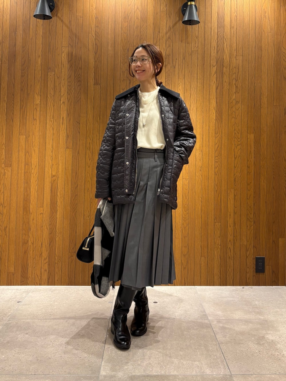 グレー系のダウンジャケット/コート、グリーン系のスカート、ブラック系のショルダーバッグを着用したレディースの冬コーディネートの5枚目の写真