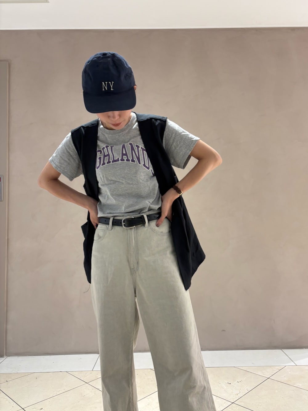 グレー系のデニムパンツ、ブラック系のダウンベストを着用したレディースの夏コーディネートの6枚目の写真