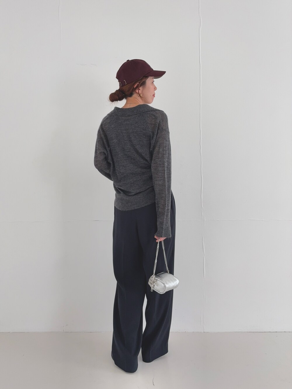 ブラック系のその他パンツ、グレー系のニット/セーター、レッド系のキャップを着用したレディースの夏コーディネートの3枚目の写真