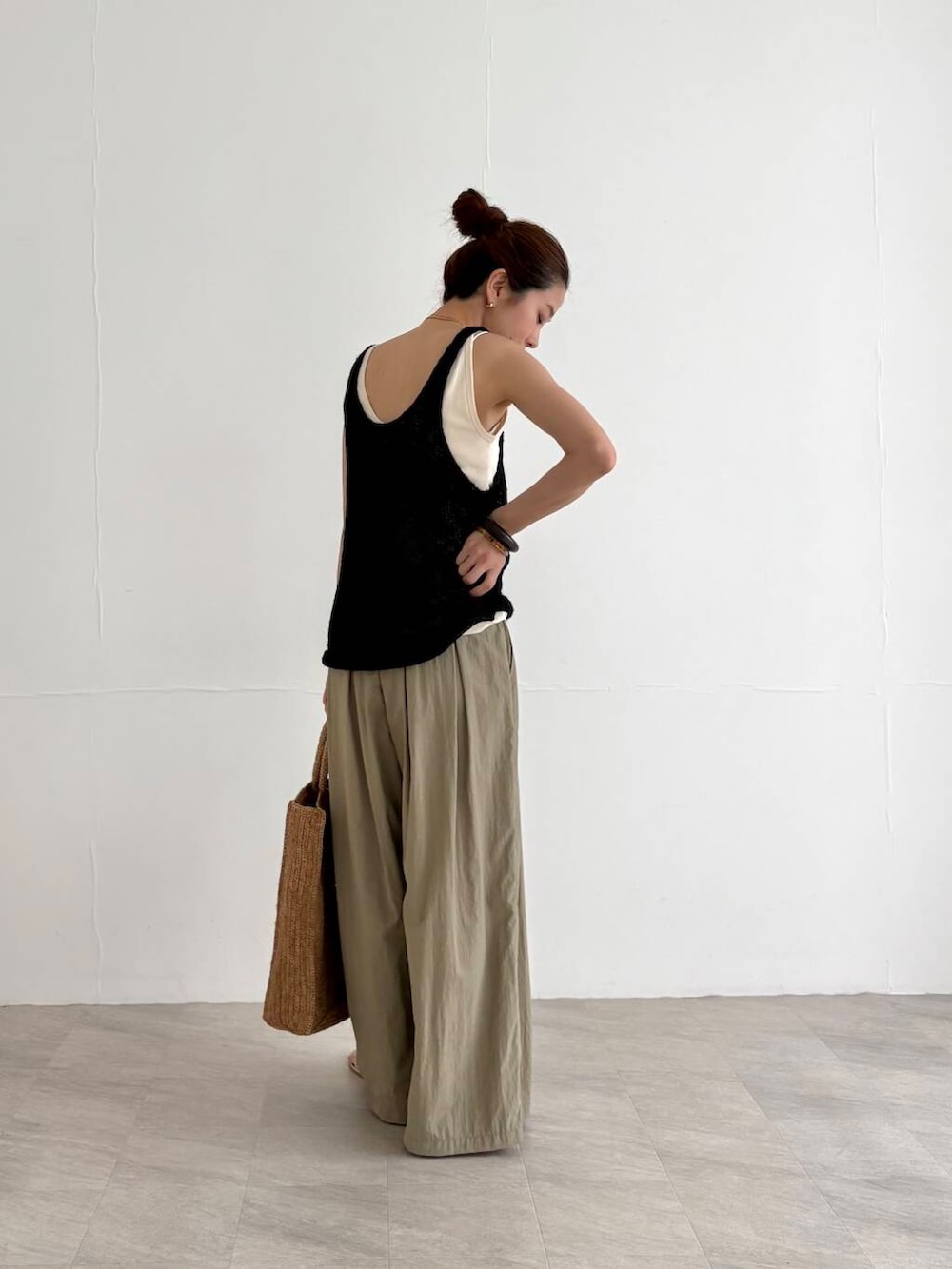 ベージュ系のその他パンツ、ホワイト系のキャミソール、ブラック系のニット/セーターを着用したレディースの夏コーディネートの2枚目の写真