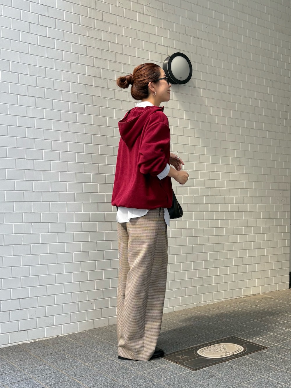 レッド系のパーカー、ブルー系のシャツ/ブラウス、グレー系のその他パンツを着用したレディースの秋コーディネートの2枚目の写真