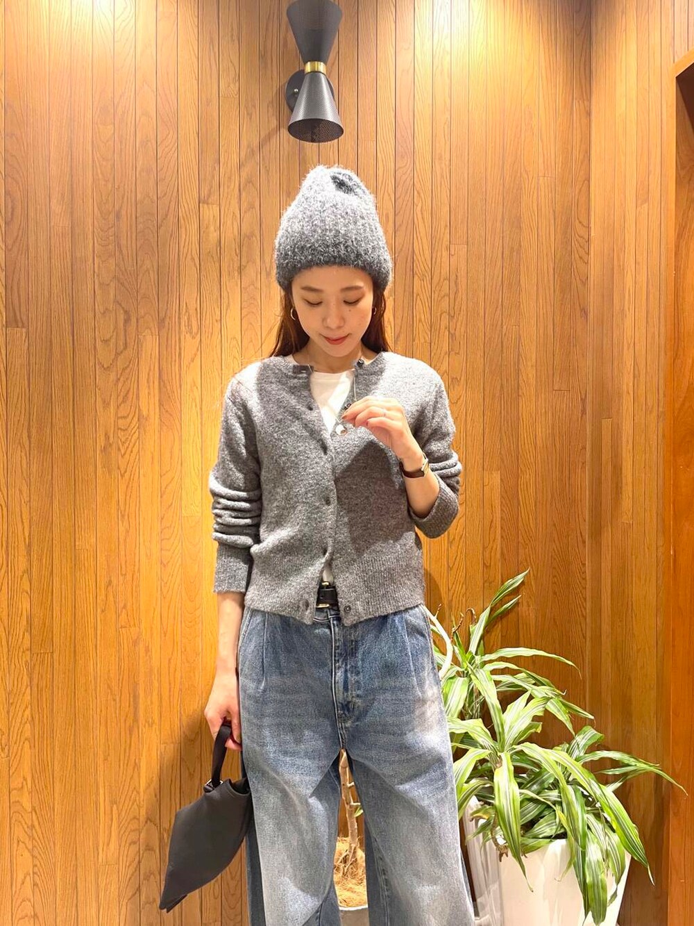 ブルー系のデニムパンツ、グレー系のカーディガン/ボレロ、ベージュ系のダウンジャケット/コートを着用したレディースの秋コーディネートの5枚目の写真