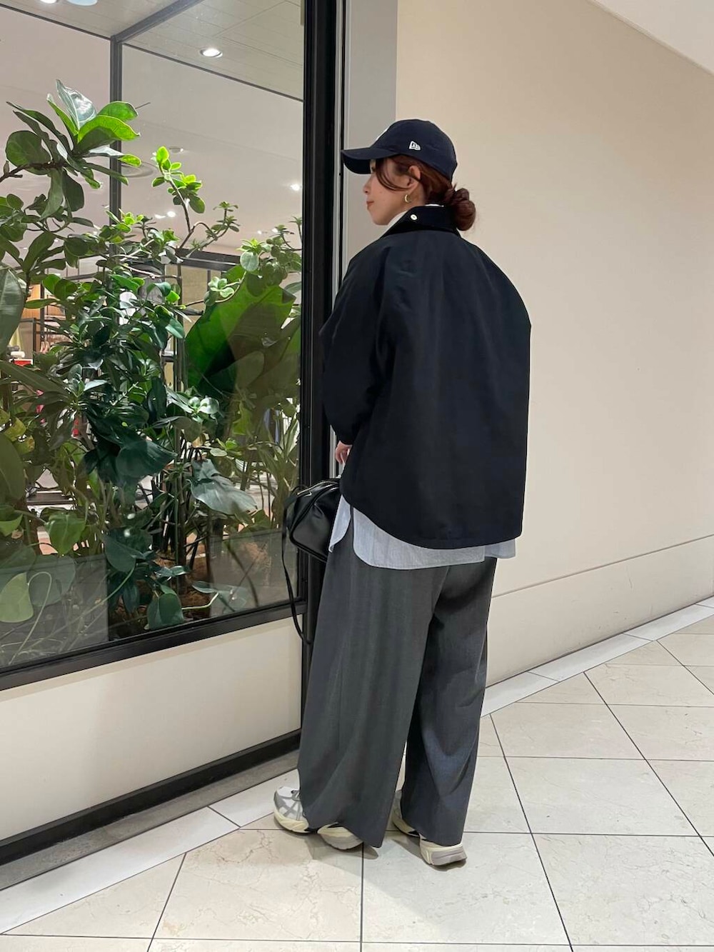 ブラック系のショルダーバッグ、ブルー系のTシャツ/カットソー、ホワイト系のスニーカーを着用したレディースの冬コーディネートの3枚目の写真