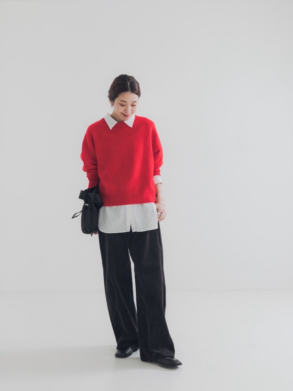 レッド系のニット/セーター、グレー系のその他パンツ、ブルー系のシャツ/ブラウスを着用したレディースの秋コーディネートの3枚目の写真