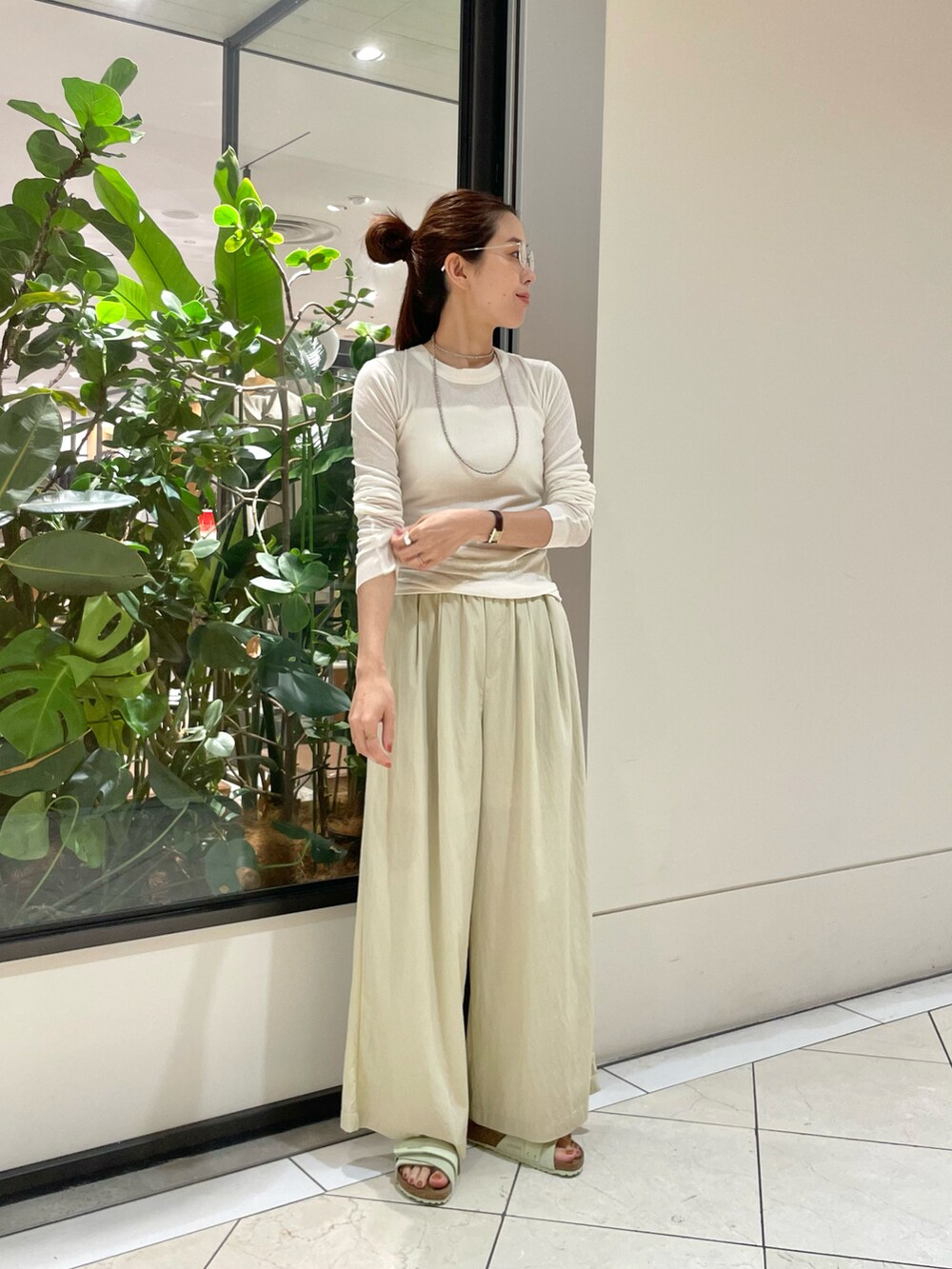 ホワイト系のトップス、ベージュ系のその他パンツ、グリーン系のサンダルを着用したレディースの夏コーディネートの2枚目の写真