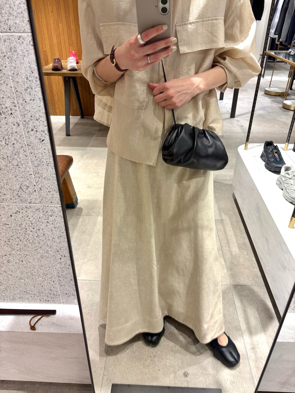 ベージュ系のスカート、ホワイト系のシャツ/ブラウス、ブラック系のショルダーバッグを着用したレディースの春コーディネートの7枚目の写真