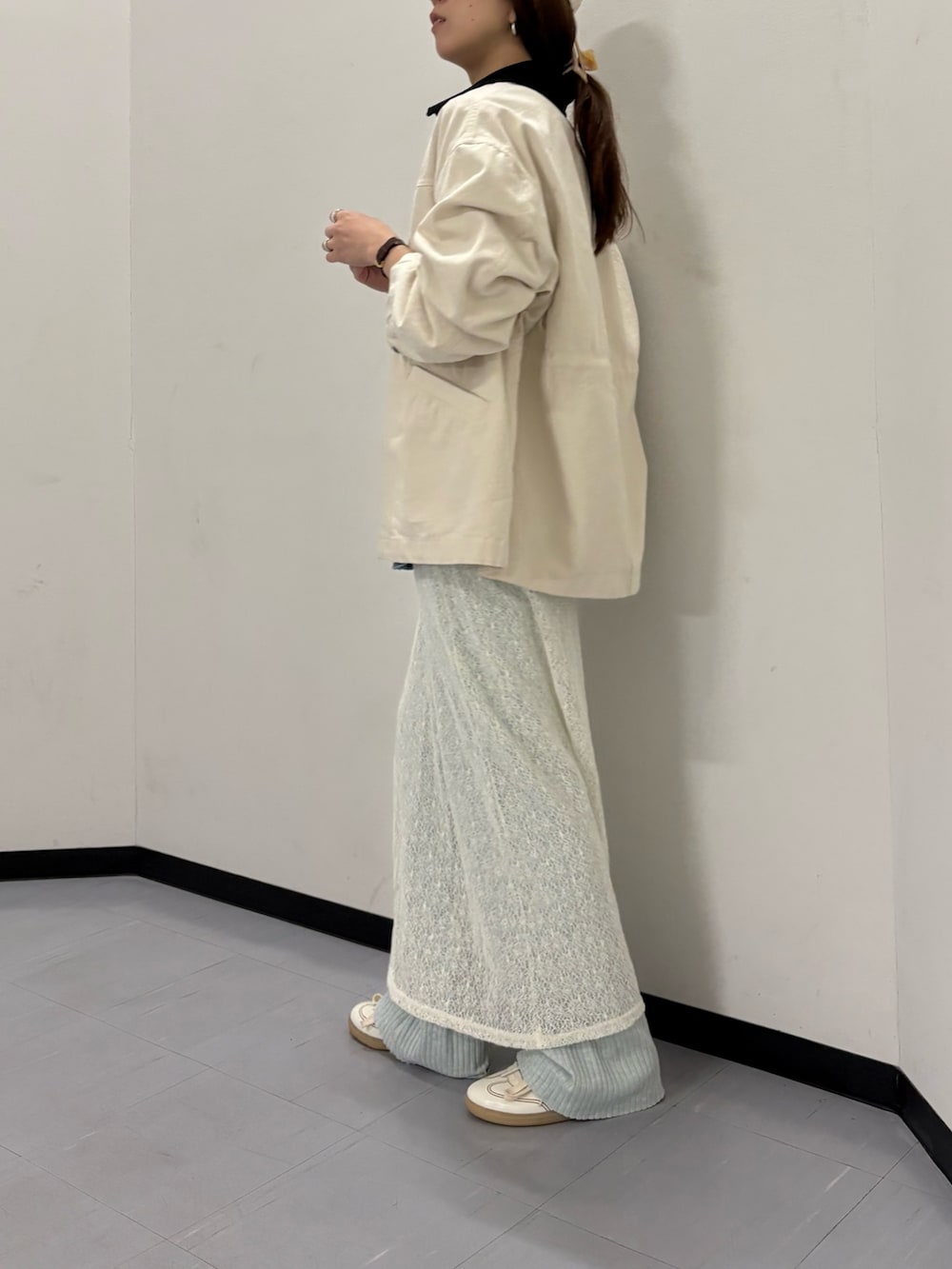 ベージュ系のカバーオール、ホワイト系のスカート、ホワイト系のスニーカーを着用したレディースの冬コーディネートの2枚目の写真