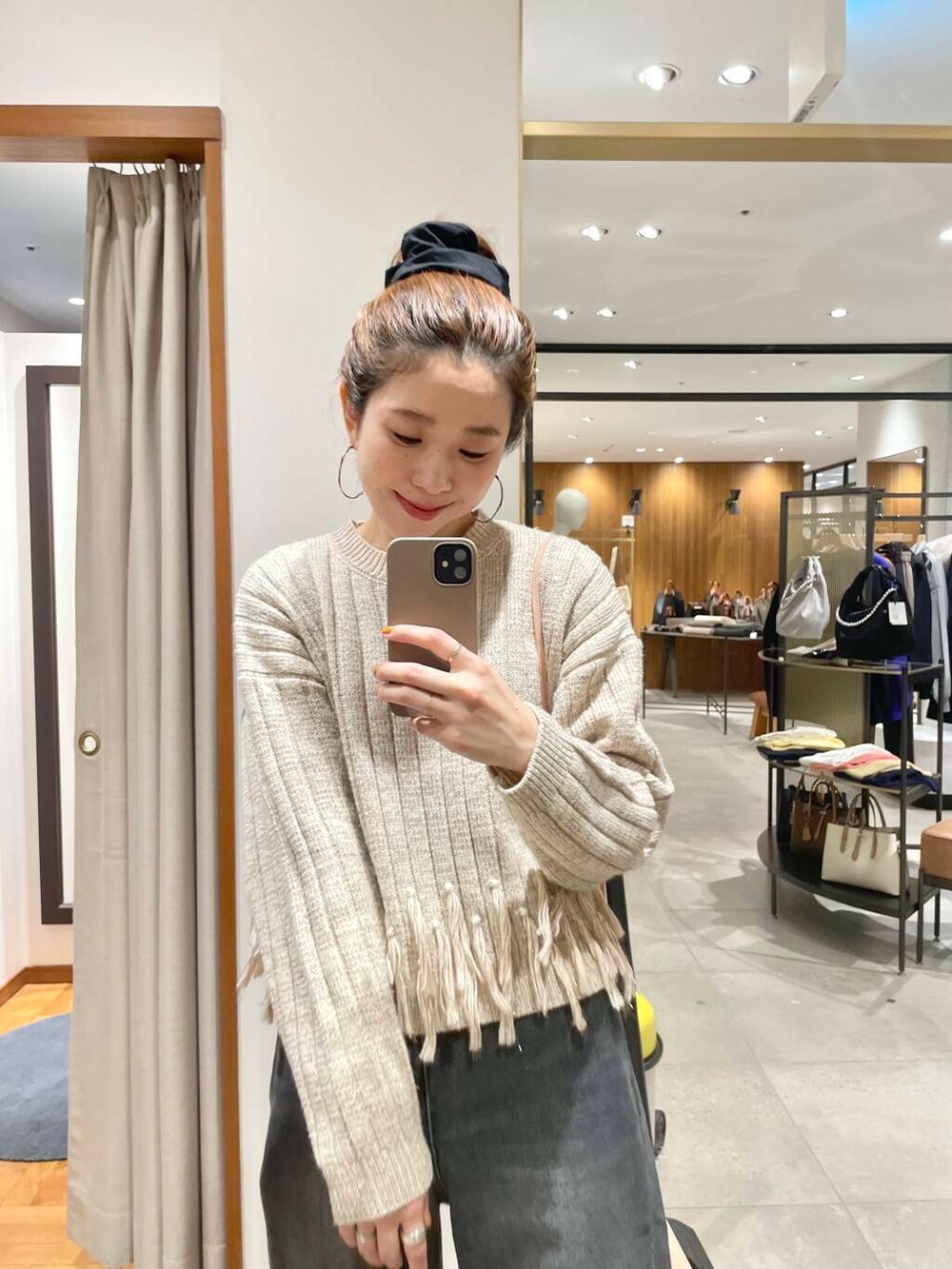 ブラック系のデニムパンツ、ブラウン系のニット/セーター、ブラック系のブーツを着用したレディースの冬コーディネートの6枚目の写真