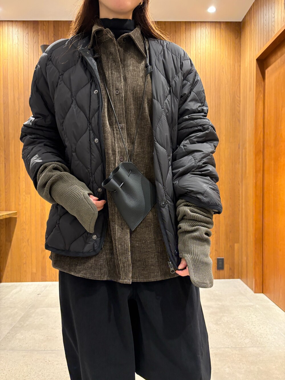 ブラック系のダウンジャケット/コート、ブルー系のその他パンツ、ホワイト系のスニーカーを着用したレディースの冬コーディネートの8枚目の写真