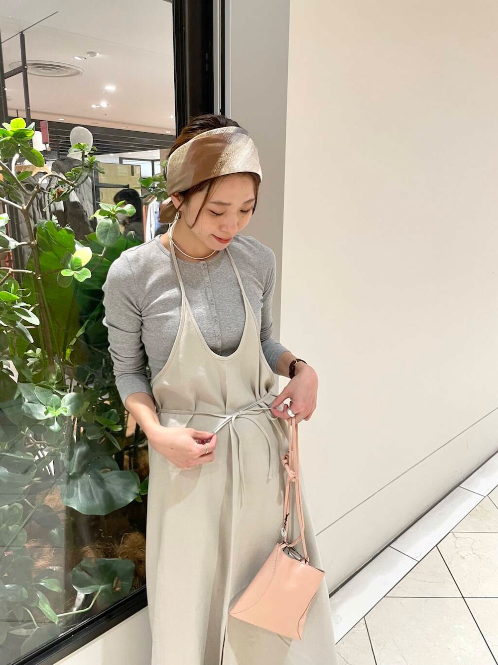 ホワイト系のその他パンツ、ブラウン系のワンピース、グレー系のTシャツ/カットソーを着用したレディースの冬コーディネートの6枚目の写真