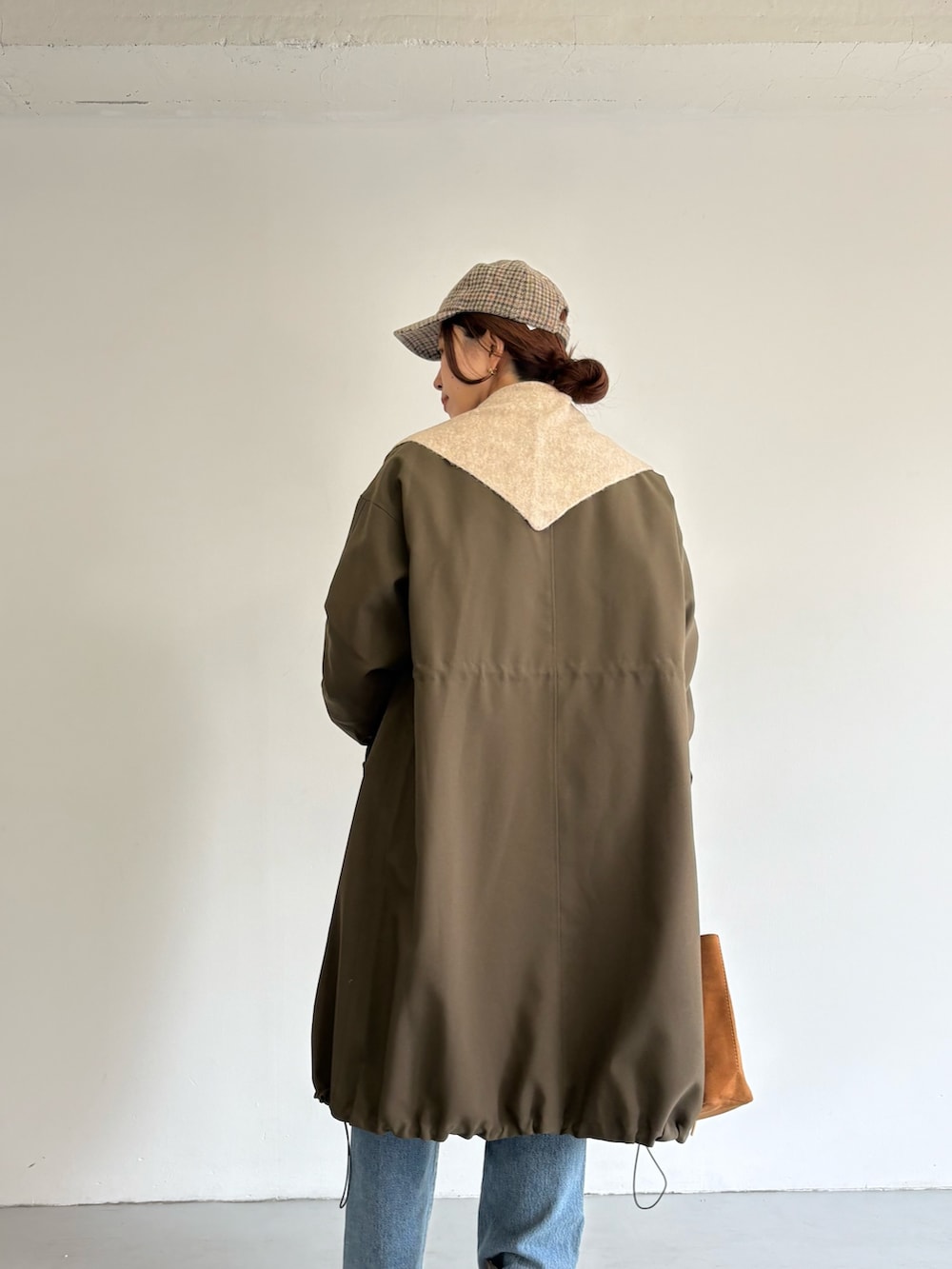 ブルー系のデニムパンツ、ベージュ系のトートバッグ、ホワイト系のTシャツ/カットソーを着用したレディースの冬コーディネートの4枚目の写真