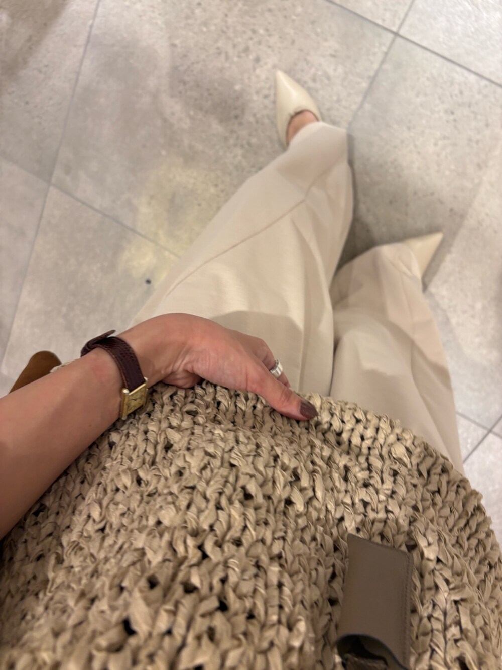 グレー系のニット/セーター、ホワイト系のその他パンツ、ブラウン系のトートバッグを着用したレディースの秋コーディネートの7枚目の写真