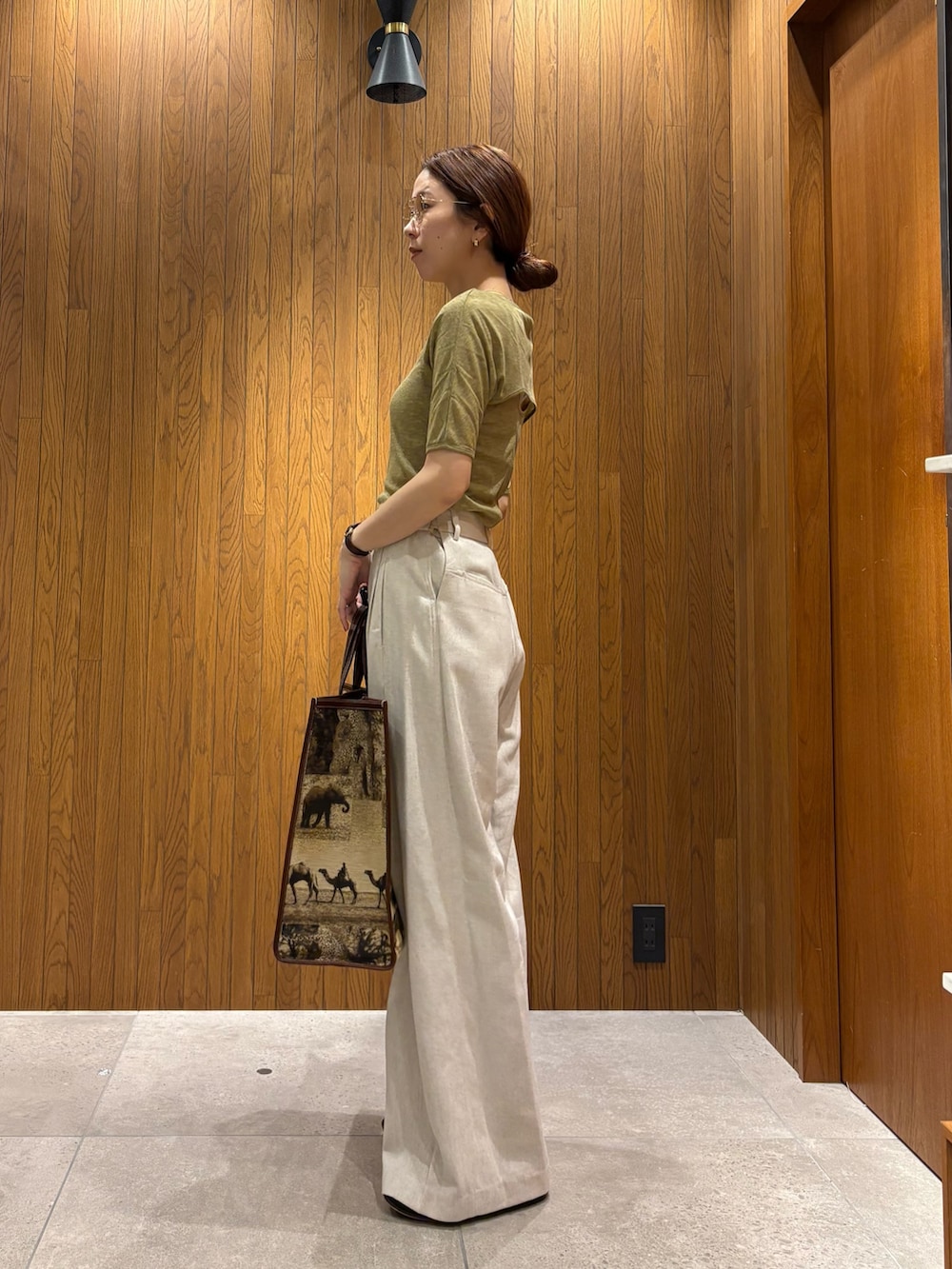 ホワイト系のその他パンツ、グリーン系のTシャツ/カットソー、ベージュ系のハンドバッグを着用したレディースの春コーディネートの2枚目の写真