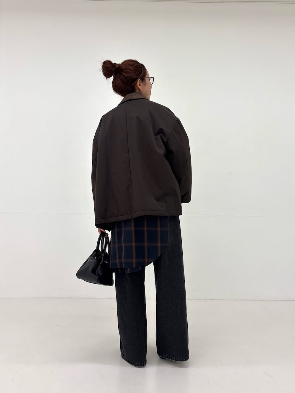 ホワイト系のシャツ/ブラウス、ブラック系のデニムパンツ、ブラック系のハンドバッグを着用したレディースの秋コーディネートの3枚目の写真