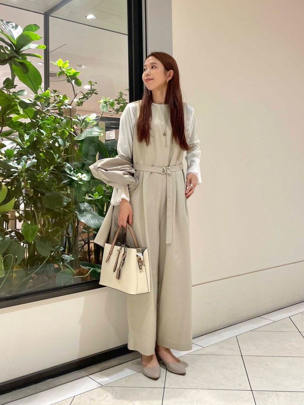 ホワイト系のトートバッグ、ベージュ系のパンプス、ホワイト系のシャツ/ブラウスを着用したレディースの冬コーディネートの6枚目の写真