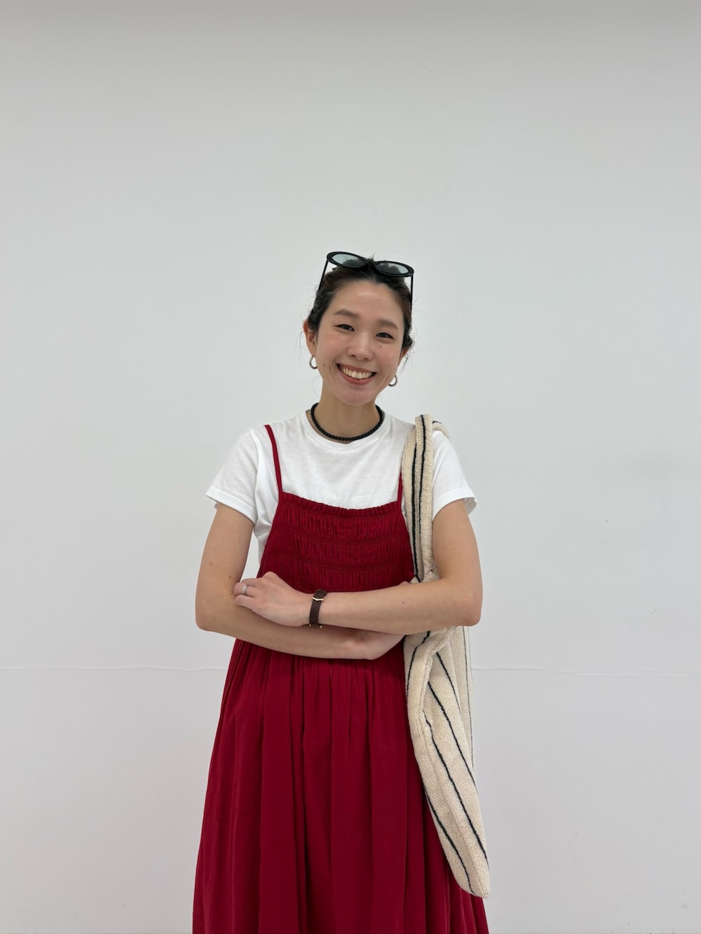 レッド系のワンピース、ホワイト系のトートバッグ、ブルー系のデニムパンツを着用したレディースの春コーディネートの5枚目の写真