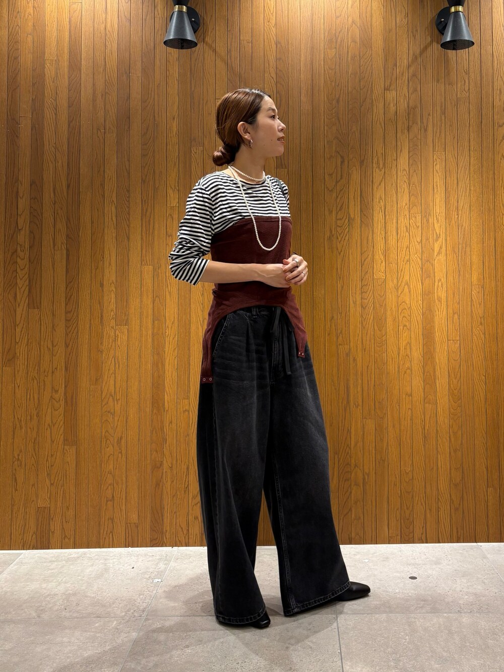 ブルー系のデニムパンツ、ブラック系のショルダーバッグ、その他のTシャツ/カットソーを着用したレディースの夏コーディネートの2枚目の写真