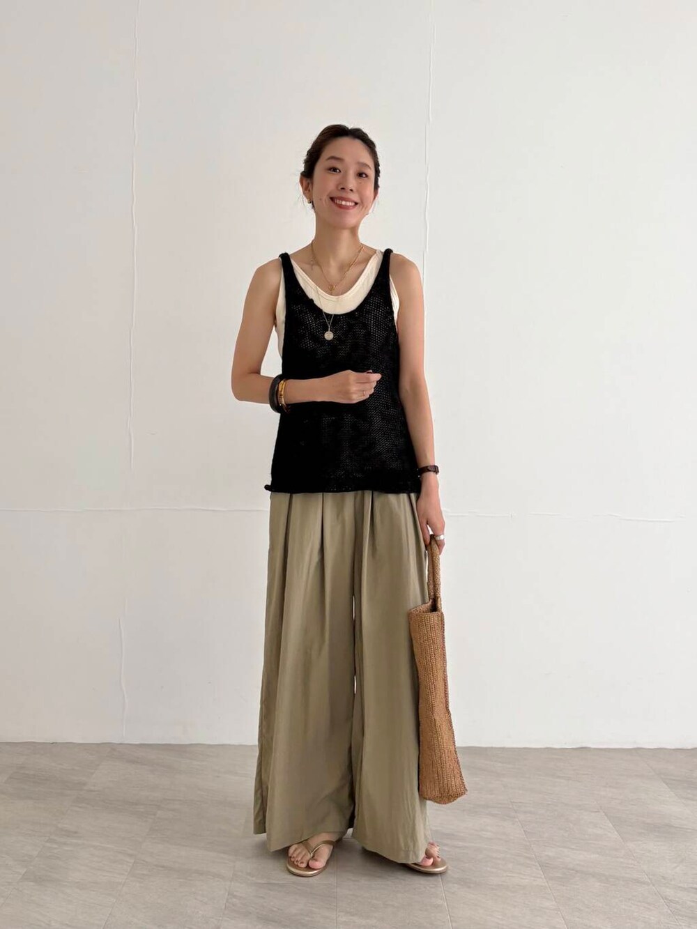 ベージュ系のその他パンツ、ホワイト系のキャミソール、ブラック系のニット/セーターを着用したレディースの夏コーディネートの4枚目の写真