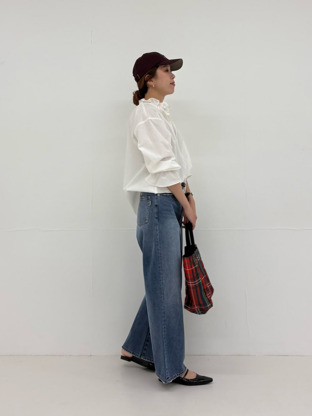 グレー系のトートバッグ、ブラック系のパンプス、ブルー系のデニムパンツを着用したレディースの夏コーディネートの4枚目の写真