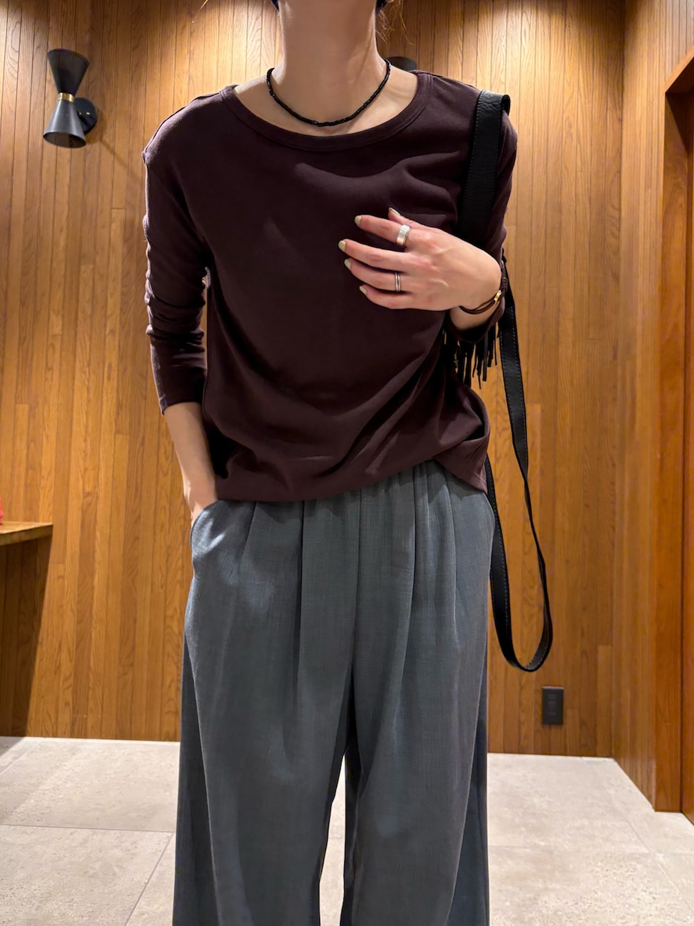 グレー系のその他パンツ、シルバー系のスニーカー、ブラック系のハンドバッグを着用したレディースの春コーディネートの5枚目の写真