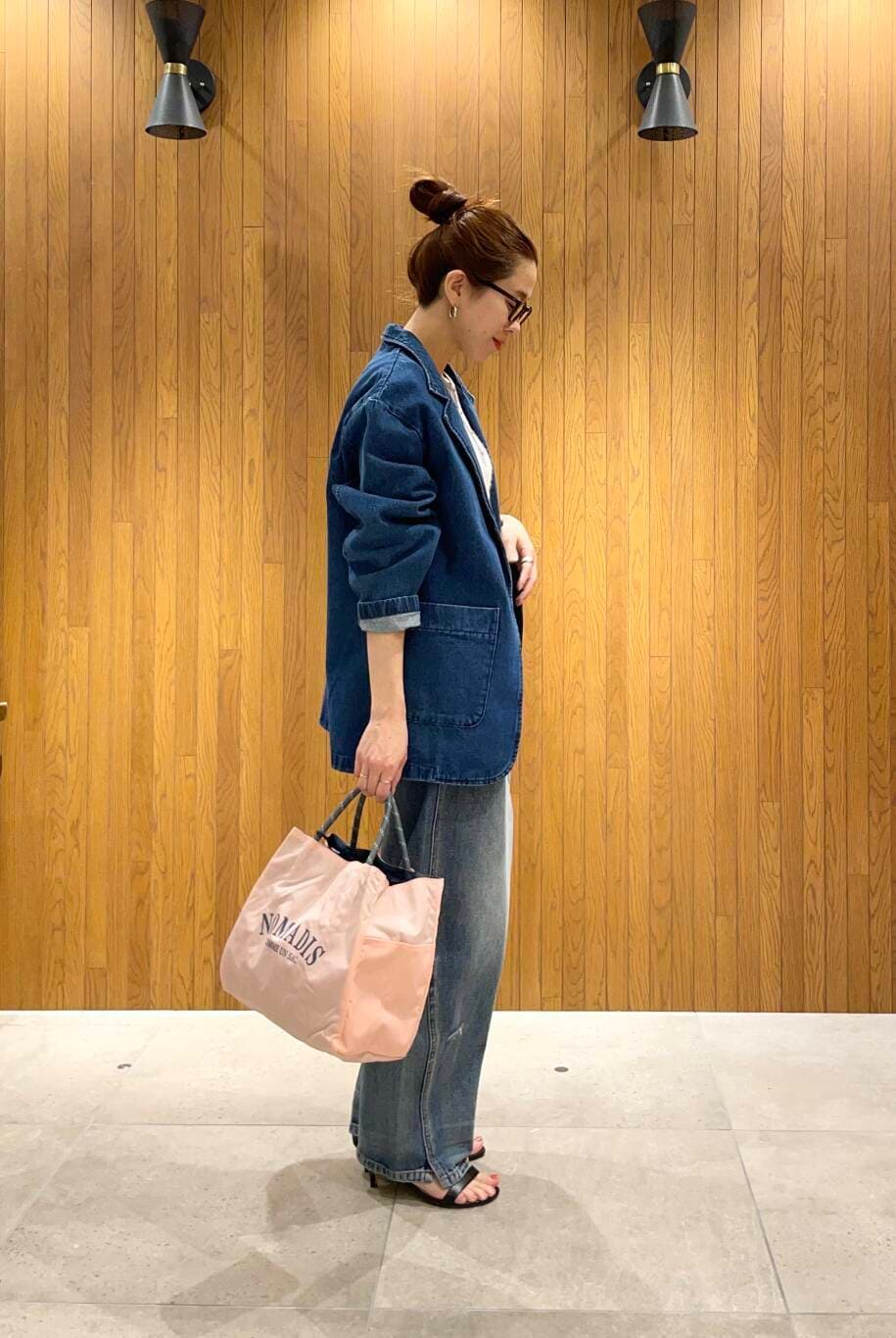 ブルー系のデニムパンツ、ブルー系のデニムジャケット、ホワイト系のキャミソールを着用したレディースの冬コーディネートの2枚目の写真