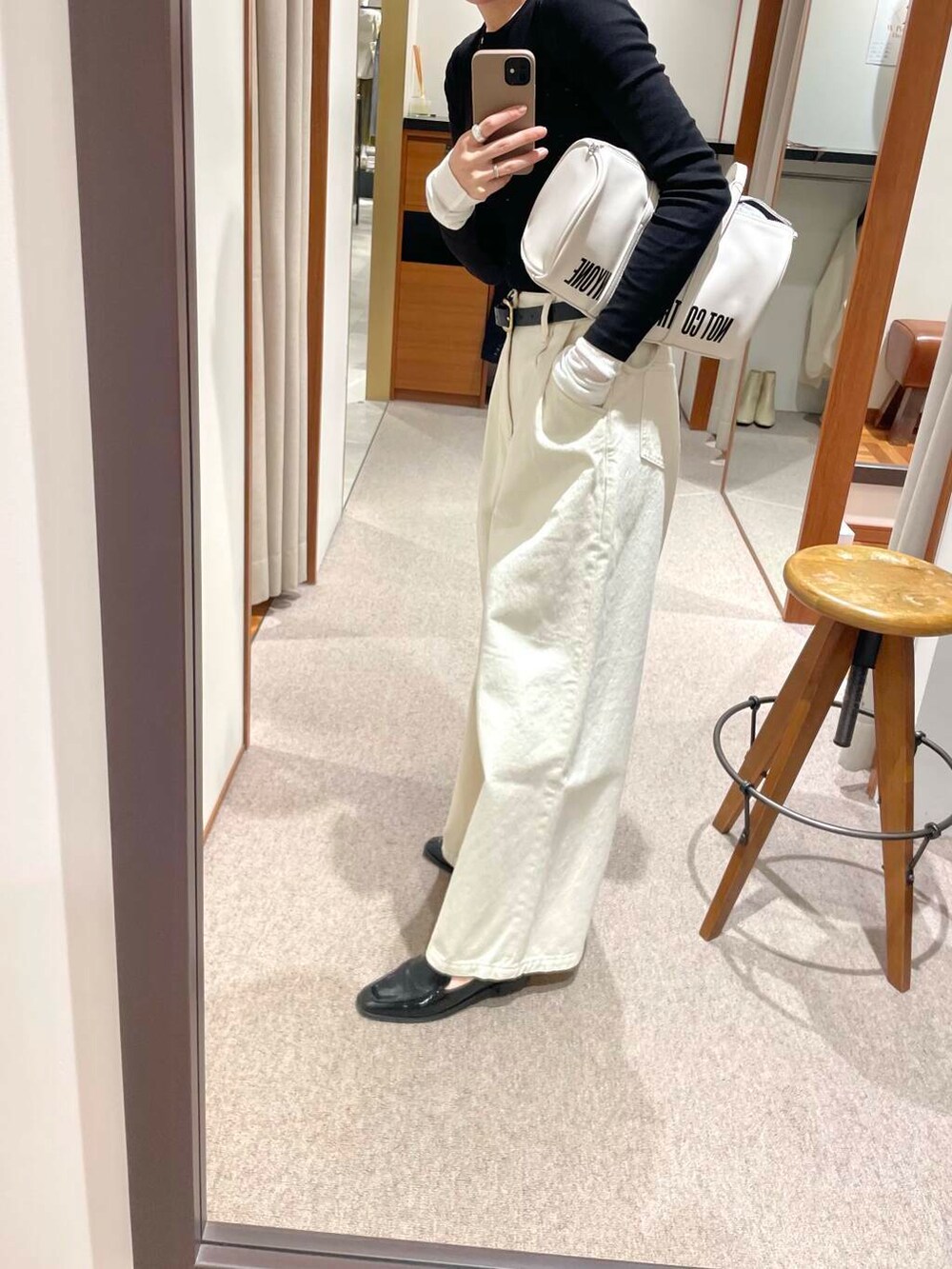 ブラック系のローファー、ホワイト系のボストンバッグ、ホワイト系のデニムパンツを着用したレディースの冬コーディネートの6枚目の写真