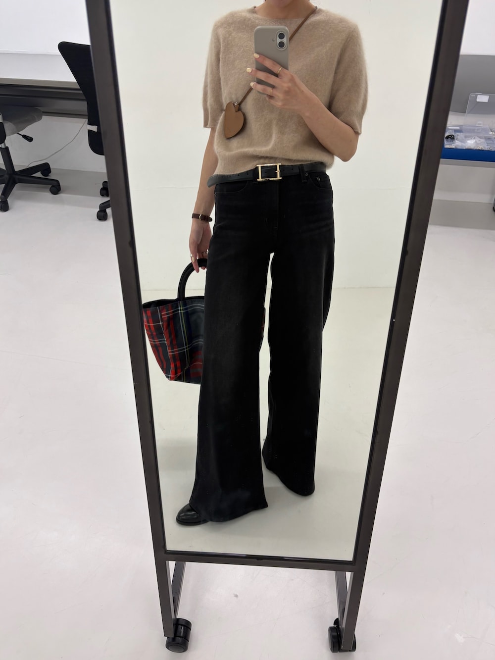 ブラック系のデニムパンツ、グレー系のトートバッグ、ベージュ系のニット/セーターを着用したレディースの夏コーディネートの6枚目の写真