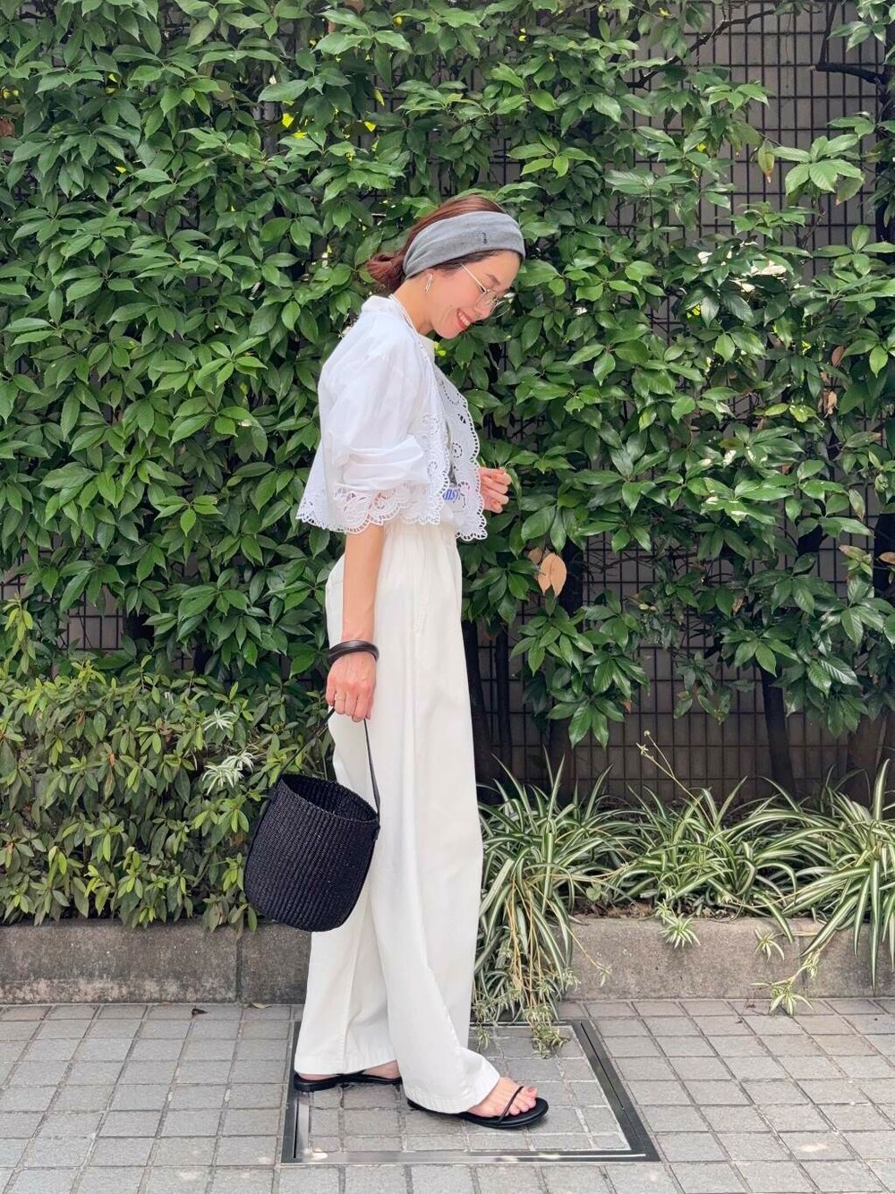 ブラック系のかごバッグ、ホワイト系のその他パンツ、ブラック系のサンダルを着用したレディースの夏コーディネートの3枚目の写真