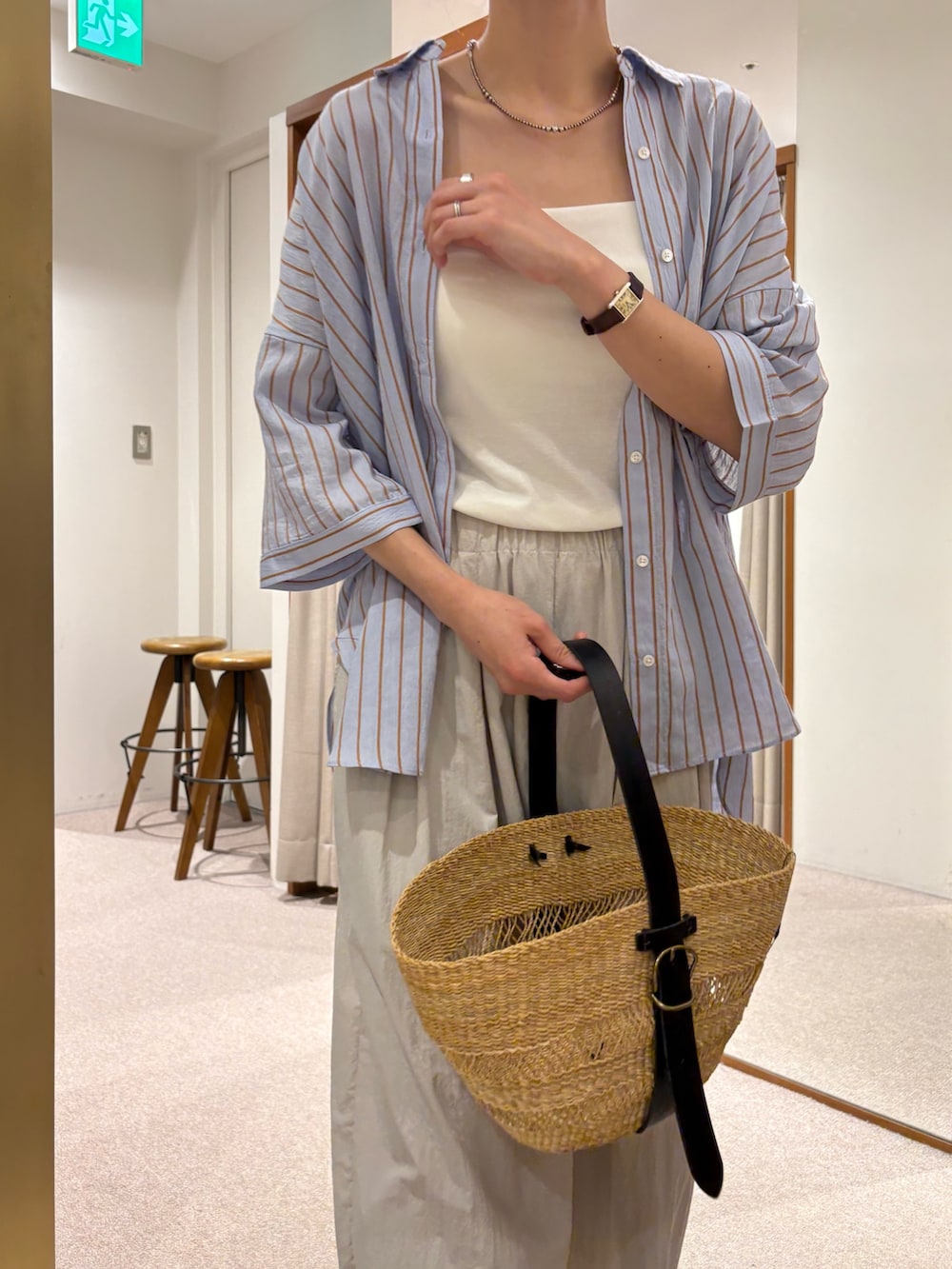 ベージュ系のかごバッグ、グレー系のその他パンツ、ブラウン系のサンダルを着用したレディースの夏コーディネートの7枚目の写真