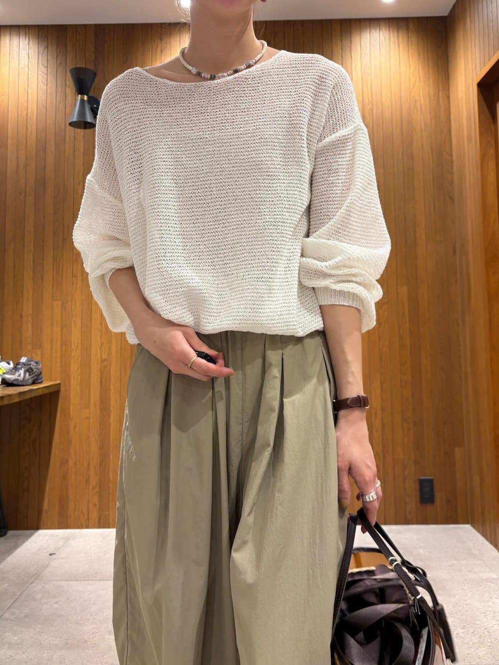ホワイト系のニット/セーター、ベージュ系のその他パンツ、ブラウン系のかごバッグを着用したレディースの春コーディネートの6枚目の写真
