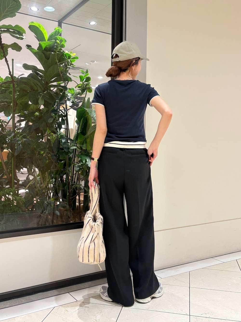 ブラック系のその他パンツ、グレー系のスニーカー、ホワイト系のハンドバッグを着用したレディースの夏コーディネートの3枚目の写真