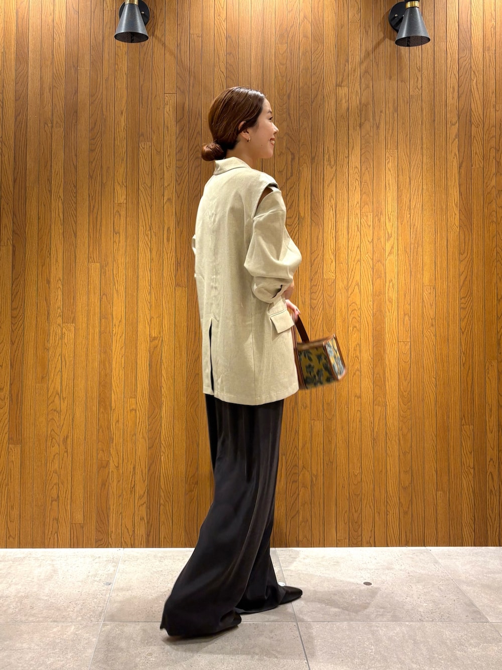 ホワイト系のその他アウター、ブラウン系のその他パンツ、ベージュ系のハンドバッグを着用したレディースの秋コーディネートの4枚目の写真