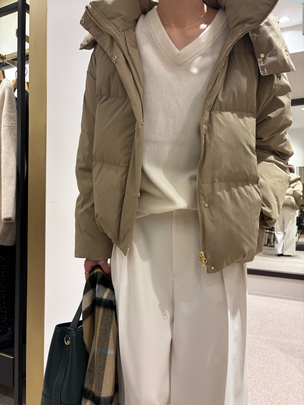 ベージュ系のダウンジャケット/コート、グリーン系のニット/セーター、ホワイト系のその他パンツを着用したレディースの秋コーディネートの6枚目の写真