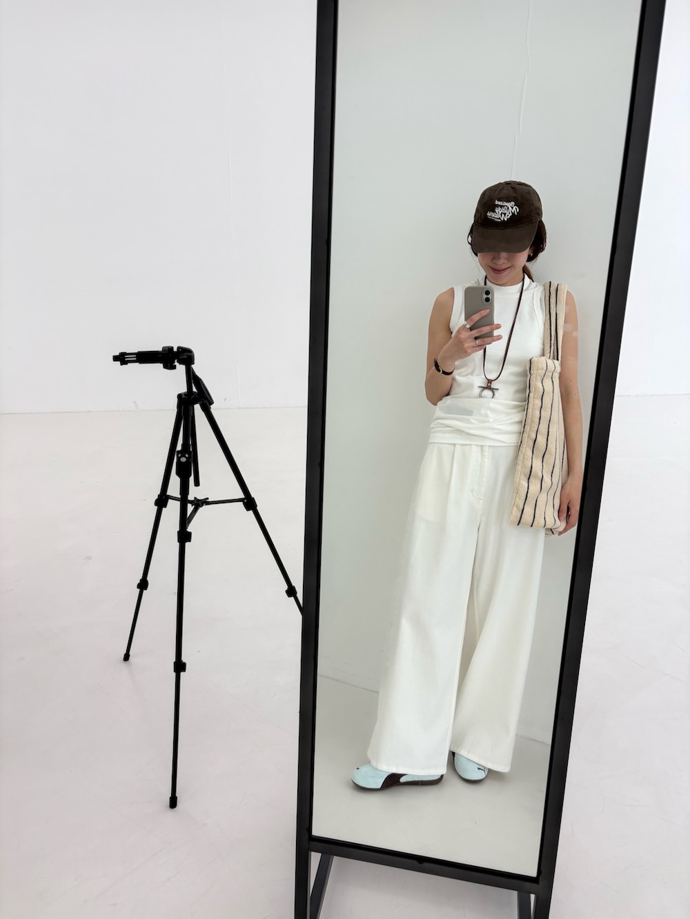 ホワイト系のデニムパンツ、ホワイト系のキャミソール、ホワイト系のタンクトップを着用したレディースの夏コーディネートの8枚目の写真