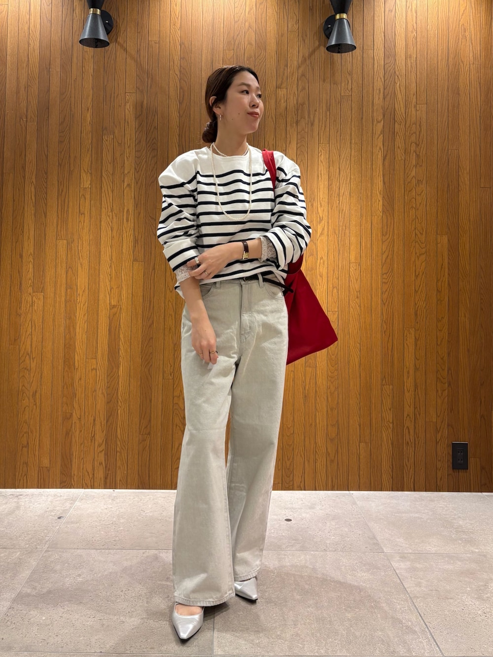 ベージュ系のトレンチコート、グレー系のデニムパンツ、シルバー系のパンプスを着用したレディースの冬コーディネートの7枚目の写真