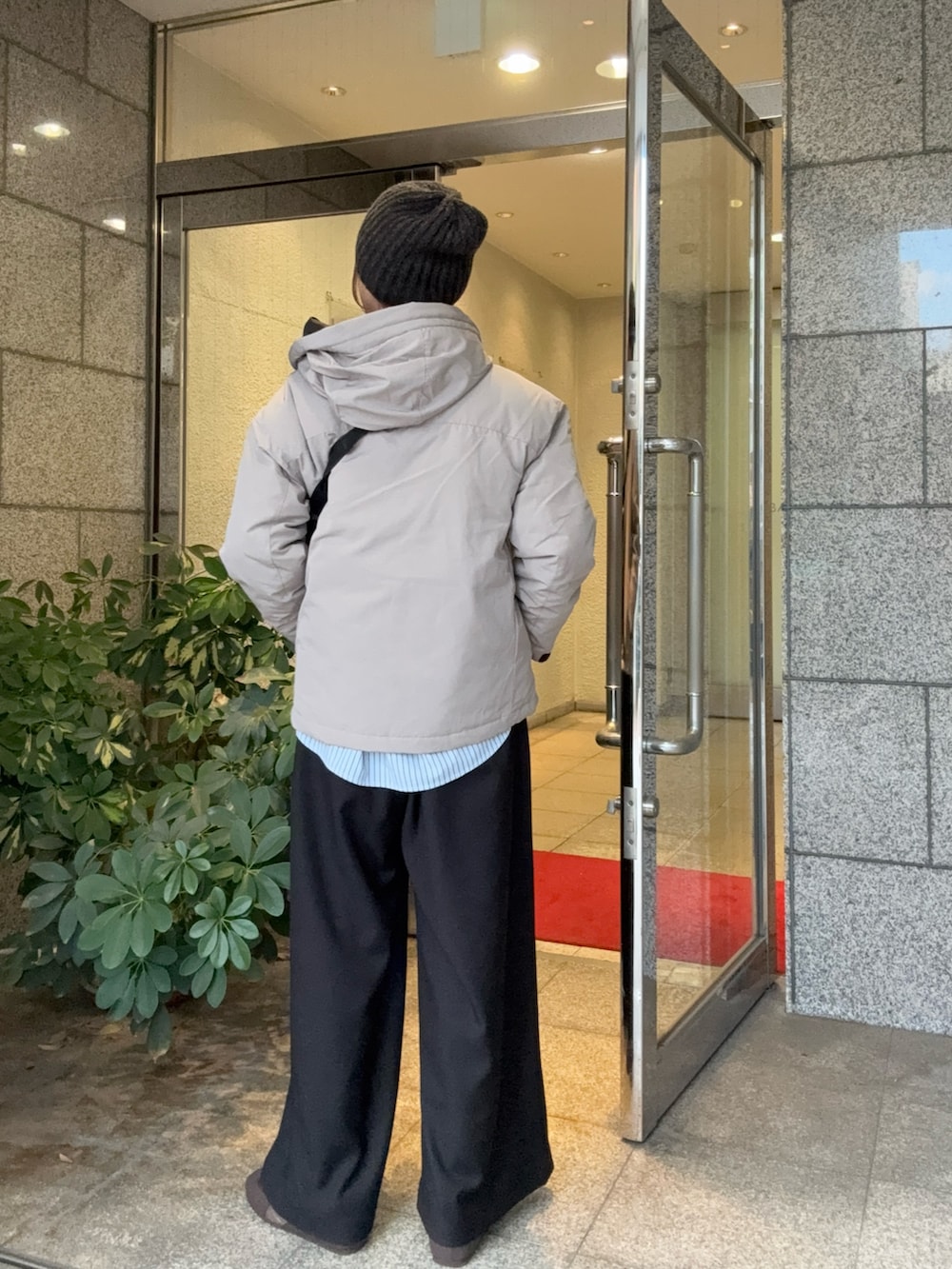 グレー系のダウンジャケット/コート、ブラック系のその他パンツ、ブラウン系のスニーカーを着用したレディースの秋コーディネートの3枚目の写真