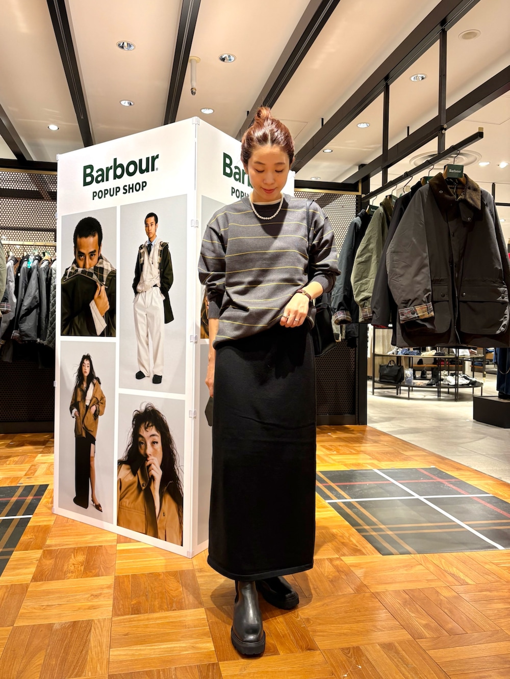 ブラック系のブーツ、ブラック系のショルダーバッグ、ブラック系のスカートを着用したレディースの秋コーディネートの2枚目の写真