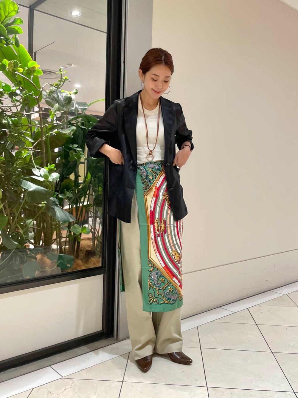 ホワイト系のタンクトップ、ブラック系のテーラードジャケット、ベージュ系のチノパンツを着用したレディースの夏コーディネートの2枚目の写真