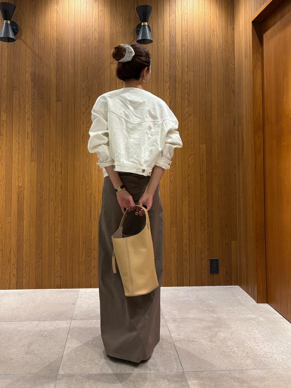 グレー系のスカート、ホワイト系のTシャツ/カットソー、ベージュ系のハンドバッグを着用したレディースの春コーディネートの3枚目の写真