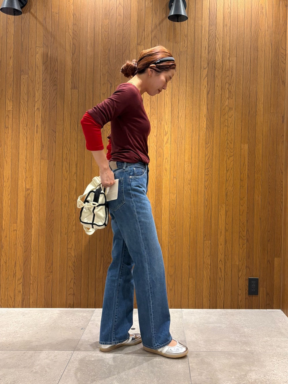 レッド系のTシャツ/カットソー、ブルー系のデニムパンツ、シルバー系のスニーカーを着用したレディースの夏コーディネートの2枚目の写真