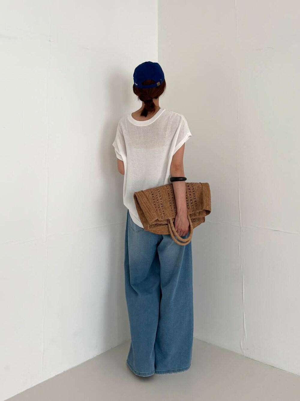 ホワイト系のキャミソール、ブルー系のデニムパンツ、ホワイト系のニット/セーターを着用したレディースの夏コーディネートの3枚目の写真