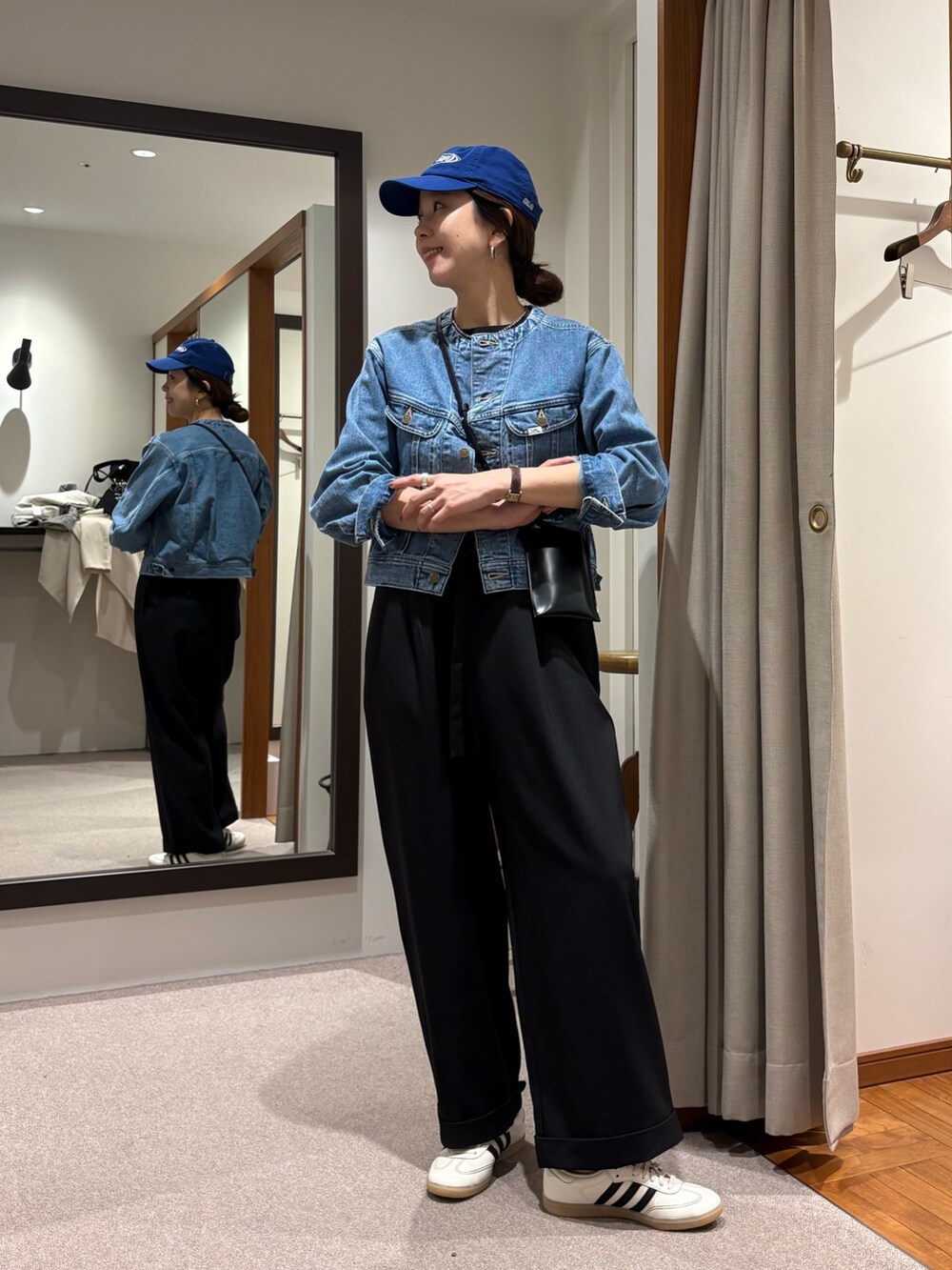 ブルー系のデニムジャケット、ブラック系のその他パンツ、ホワイト系のスニーカーを着用したレディースの冬コーディネートの5枚目の写真