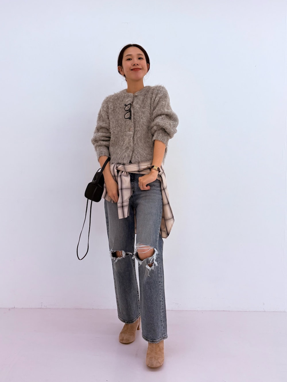 ブルー系のデニムパンツ、グリーン系のカーディガン/ボレロ、ホワイト系のピーコートを着用したレディースの秋コーディネートの5枚目の写真