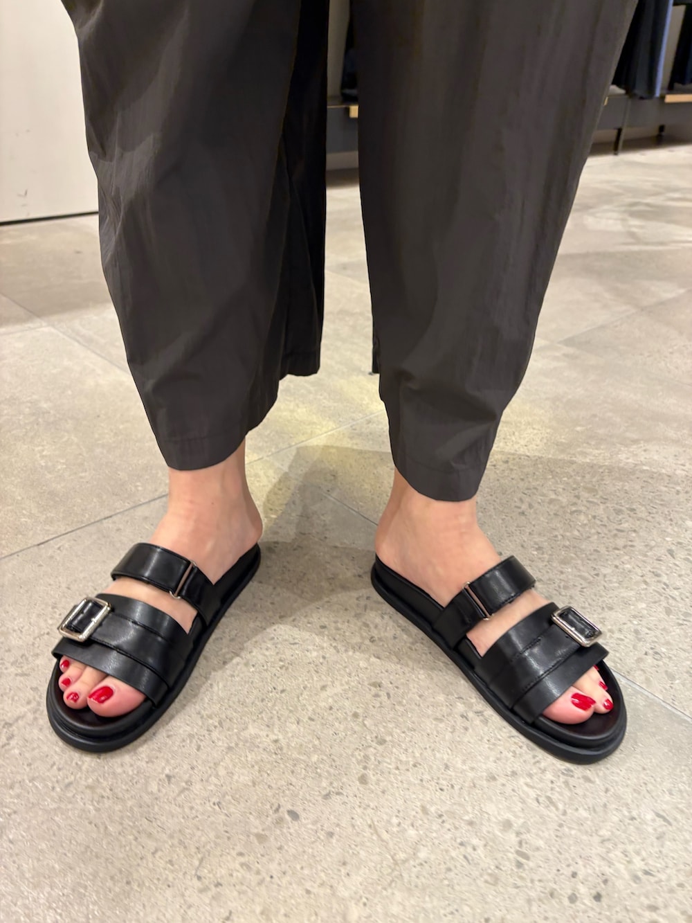 グレー系のその他パンツ、ブラック系のニット/セーター、ホワイト系のハンドバッグを着用したレディースの春コーディネートの8枚目の写真