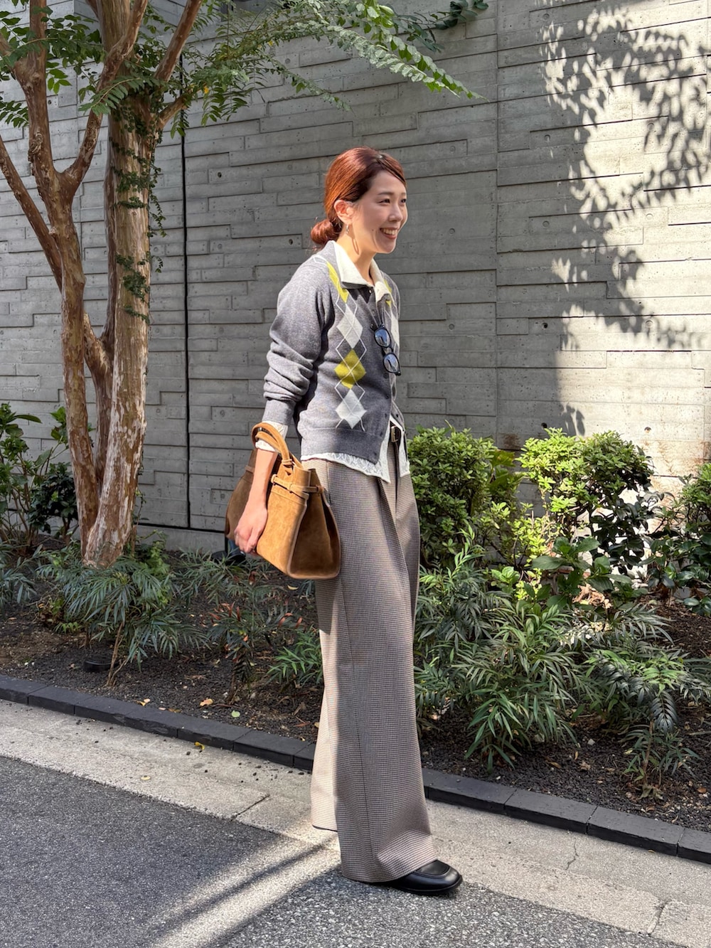 グレー系のニット/セーター、ホワイト系のシャツ/ブラウス、グレー系のその他パンツを着用したレディースの秋コーディネートの2枚目の写真